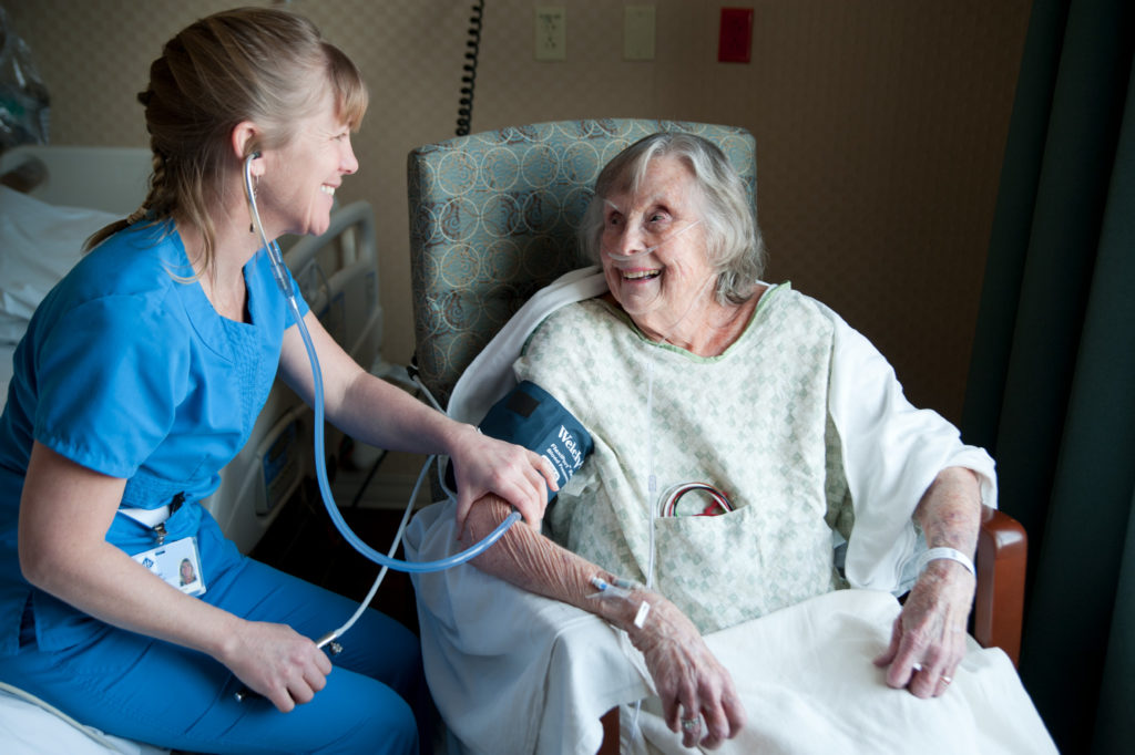 MVH Clincian taking blood pressure of an elderly patient while they smile at each other